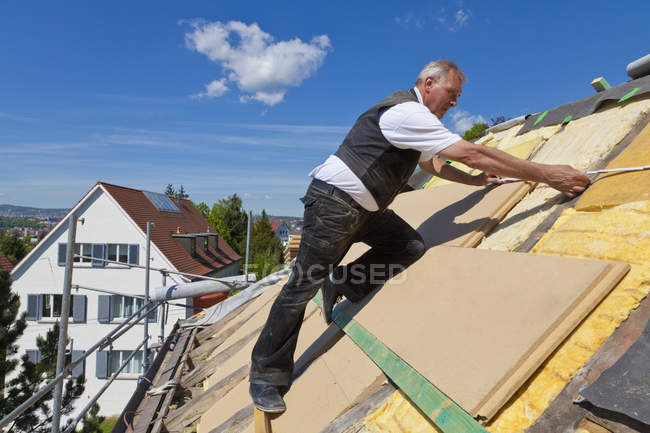 Mature man placing insulation — Stock Photo