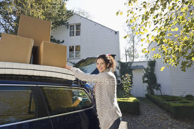 , Mid adult woman standing near car, smiling, portrait — Stock Photo
