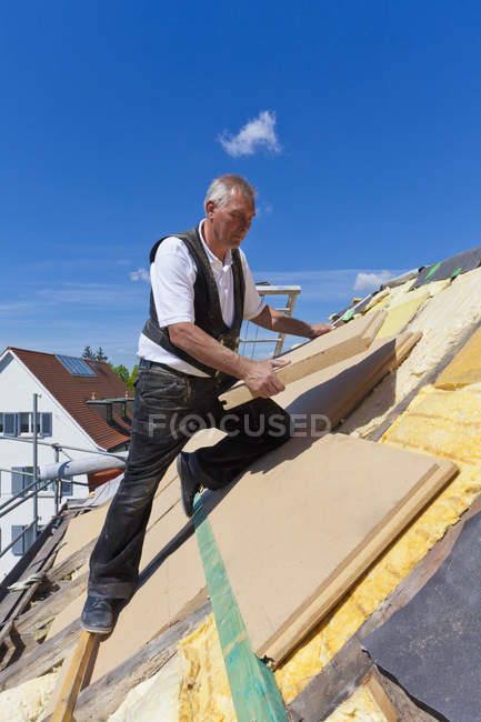 Mature man placing insulation — Stock Photo