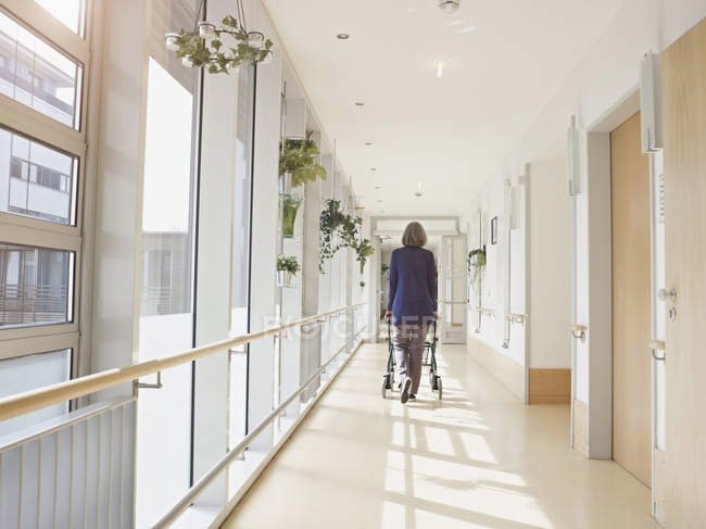 Seniorin mit Gehgestell auf Flur in Pflegeheim — Stockfoto
