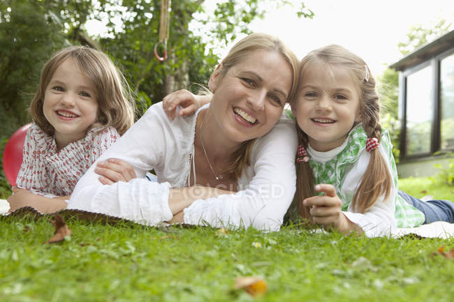 Cute family having fun in garden and smiling at daytime — Stock Photo