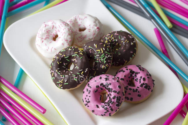 Doughnuts with icing and sprinkles — Stock Photo