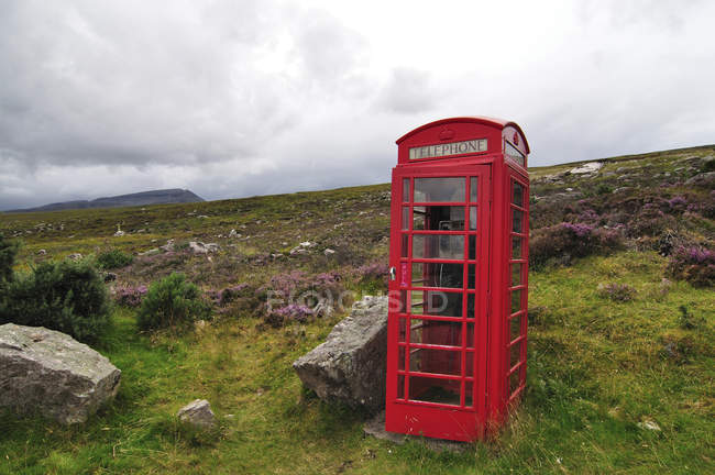 Reino Unido, Escocia, cabina telefónica roja en las Highlands durante el día - foto de stock