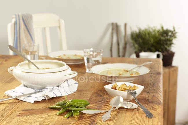 Soupe de pois maison avec croûtons sur la table de cuisine — Photo de stock