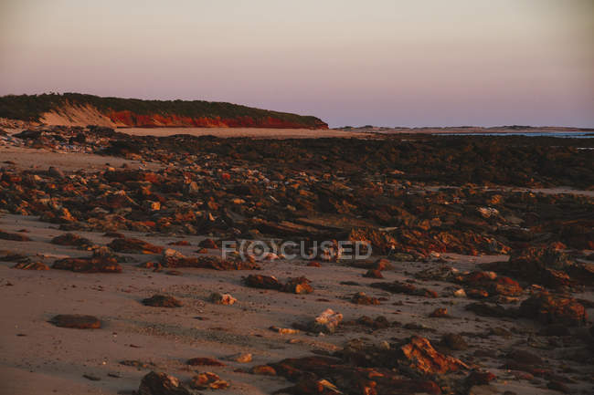 Australia, Australia Occidentale, Tramonto su una spiaggia rocciosa e sabbiosa vicino Broome — Foto stock