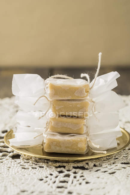 Homemade toffees in wrapping paper on tray — Stock Photo