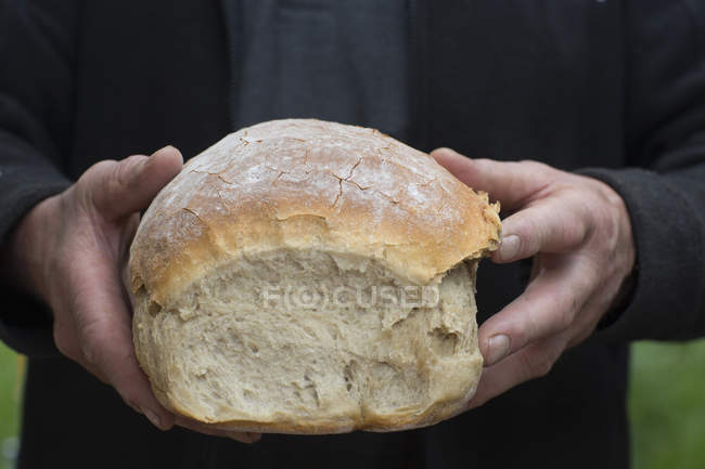 Mãos humanas segurando pão de centeio — Fotografia de Stock