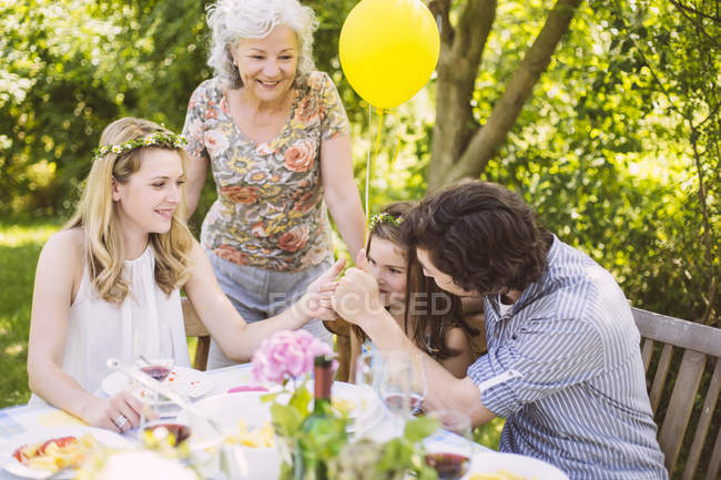 Семья из трех поколений поздравляет девушку с садовым праздником — стоковое фото