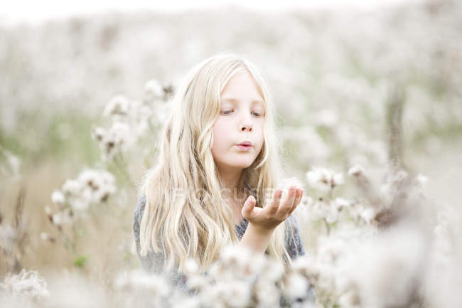 Портрет дівчина стояла в полі продування насіння руці — стокове фото