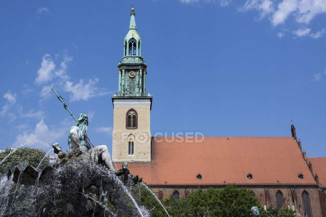Alemania, Berlín, vista a la iglesia de Santa María en Alexanderplatz con escultura de fuente neptune en primer plano - foto de stock