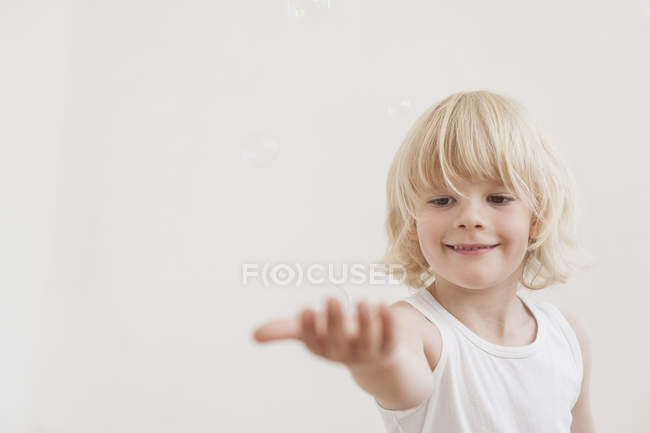Petit garçon regarder des bulles de savon — Photo de stock