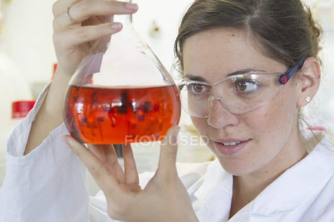 Female chemist holding Erlenmeyer flask — Stock Photo