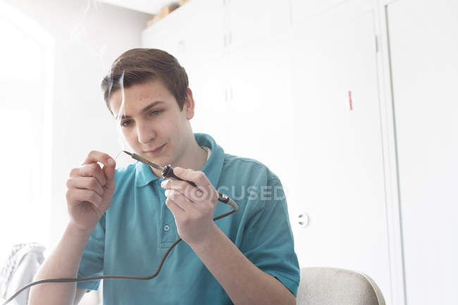 Electronic apprentice with soldering iron and wire — Stock Photo