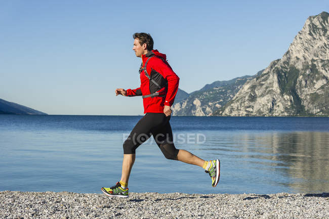 Italie, mi-adulte homme jogging par le lac de Garde — Photo de stock