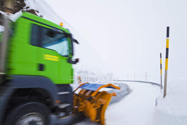Switzerland, Blurred truck clearing snow on road — Stock Photo