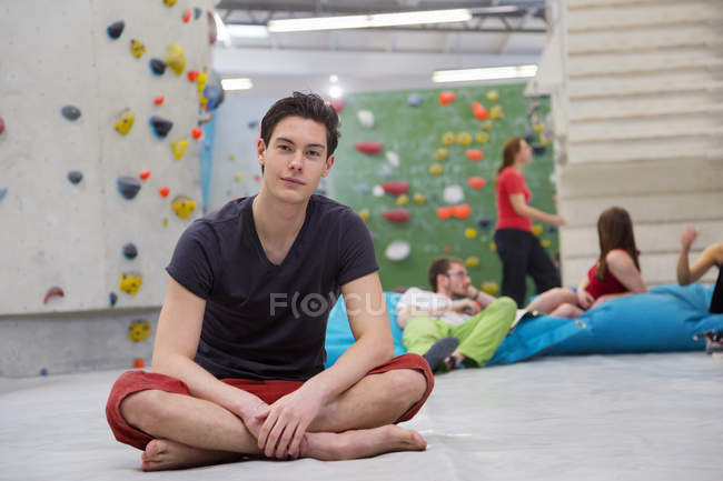 Portrait of man and friends relaxing in bouldering hall — Stock Photo