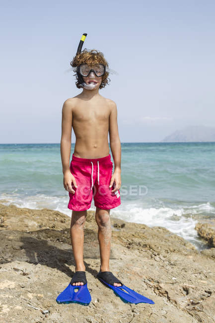 Хлопчик з обладнанням для дайвінгу стоїть на скелі — стокове фото