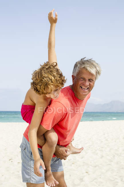 Grandfather giving piggyback ride to grandson — Stock Photo