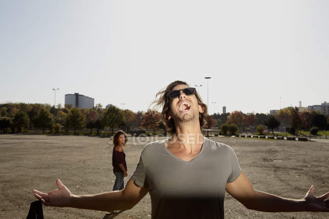 Man shouting and woman standing in background — Stock Photo