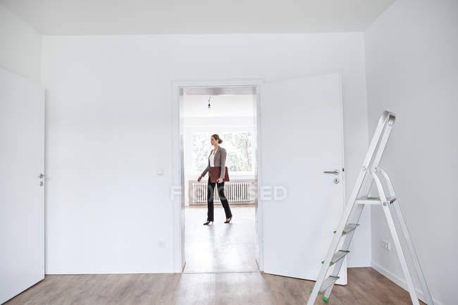 Donna con lima che cammina in casa nuova — Foto stock