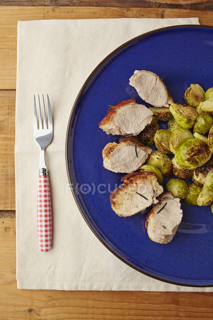 Sucklng pig roasted with brussels sprouts — Stock Photo
