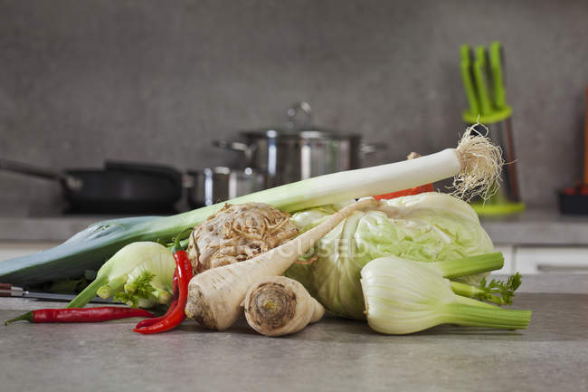 Mixed fresh vegetable in the kitchen, leek rod, celery, fenel, hot peppers, parsley roots and cabbage — Stock Photo