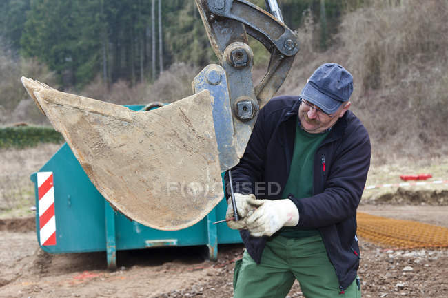 Homme mature changer pelle excavatrice — Photo de stock