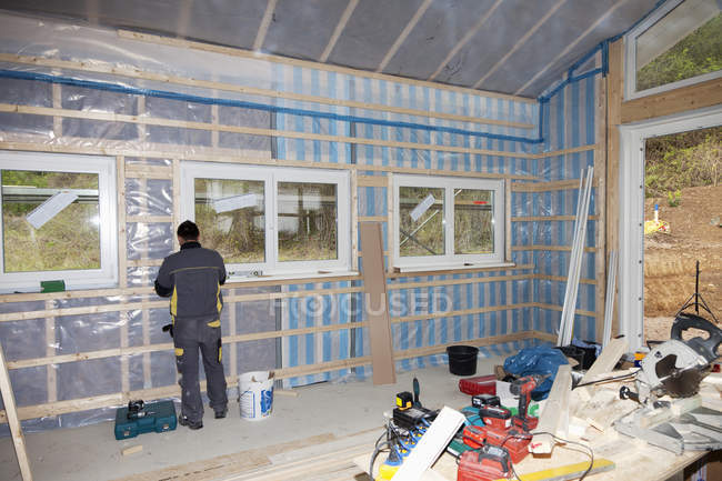Worker installing vapour barrier in building construction — Stock Photo