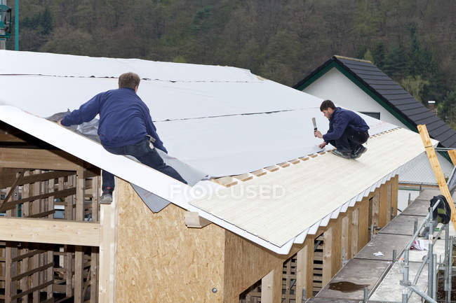 Coperture manuali di operai su casa di legno — Foto stock