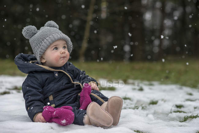 Retrato de bebê menina assistindo flocos de neve pela primeira vez — Fotografia de Stock
