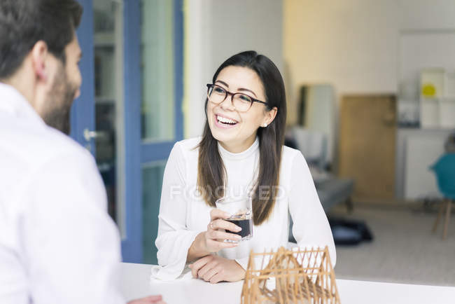 Femme riant de l'homme avec modèle architectural sur la table — Photo de stock