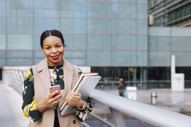 Великобритания, Лондон, портрет модной деловой женщины с мобильным телефоном, ноутбуком и ноутбуком — стоковое фото