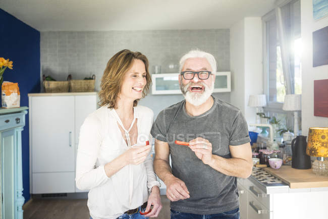 Laughing mature couple in kitchen at home — Stock Photo