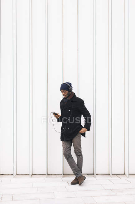 Itália, Milão, homem afro-americano com smartphone e fones de ouvido — Fotografia de Stock
