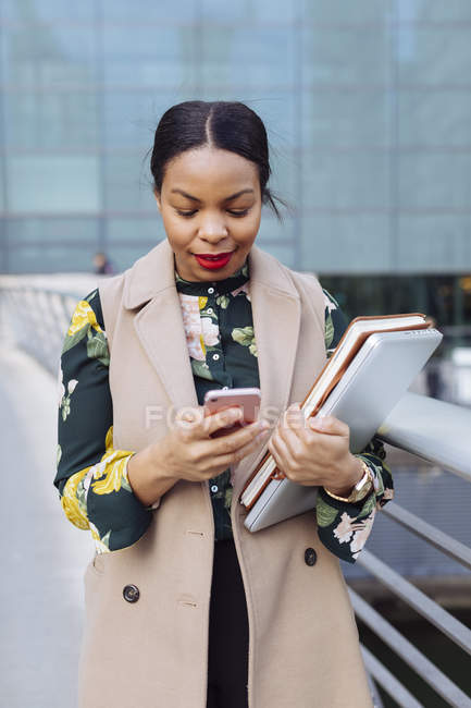 UK, London, fashionable  businesswoman looking at cell phone — Stock Photo