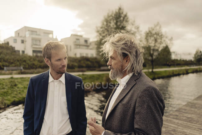 Двоє бізнесменів розмовляють на озері — Stock Photo