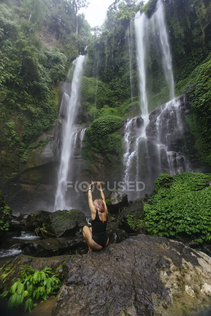 Indonésie, Bali, jeune femme accroupie à la cascade — Photo de stock