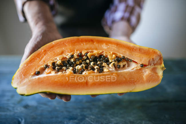 Nahaufnahme von Menschenhänden mit halber Papaya — Stockfoto