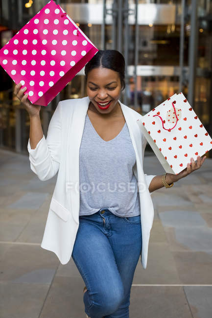 Mujer feliz sosteniendo bolsas de compras - foto de stock