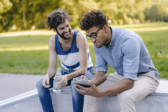 Due amici multiculturali seduti nello skatepark — Foto stock