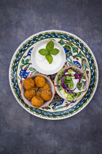 Falafel, salad, red and white cabbage, yogurt sauce with mint — Stock Photo