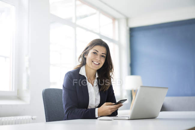 Porträt einer glücklichen Geschäftsfrau am Schreibtisch im Büro — Stockfoto