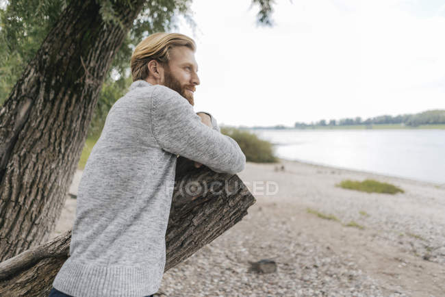 Handsome Man Sitting At Riverside On Tree Stump Blonde Hair Man