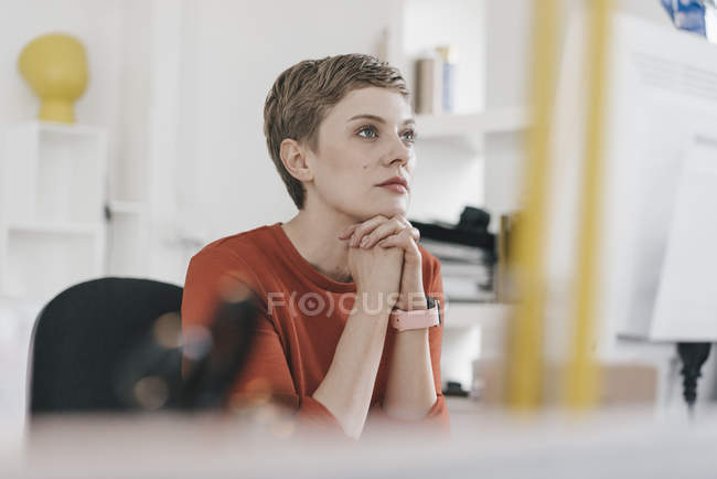 Mujer mirando la pantalla de la computadora en el escritorio en la oficina - foto de stock