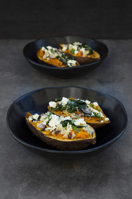 Patata dolce ripiena con spinaci, cipolla rossa, couscous, feta e coriandolo — Foto stock