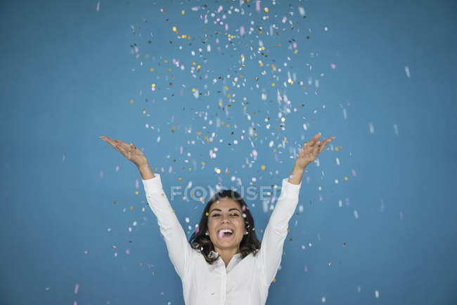 Retrato de mujer riendo lanzando confeti al aire - foto de stock
