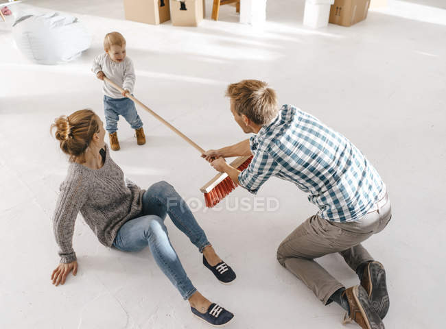 Padre e figlia si divertono con una scopa in un loft — Foto stock