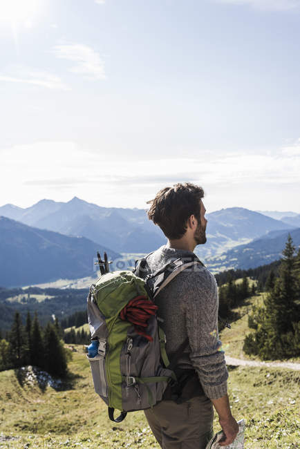 Austria, Tirol, joven en paisaje montañoso mirando a la vista - foto de stock