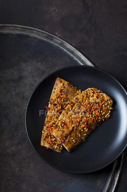 Zwei geräucherte und gewürzt Makrelenfilets auf schwarzem Teller — Stockfoto