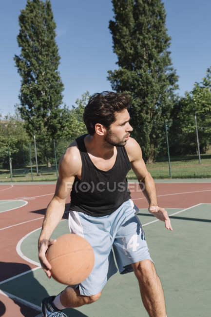 Man playing basketball on basketball ground — Stock Photo